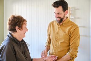 man takes the pulse of female patient