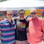 Three men pose at LGBT Pride Festival