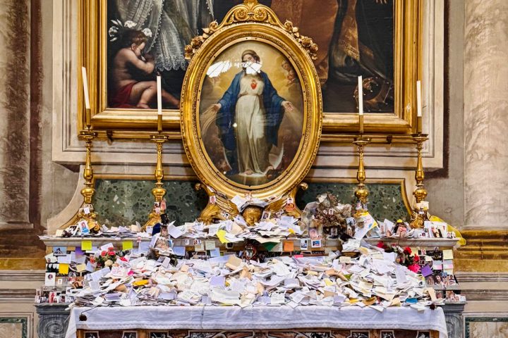 A picture of Mother Mary with a pile of letters at her feet.